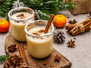 Photo of two glasses of egg nog amidst Christmas decorations