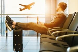 Photo of man relaxing at airport to illustrate booking holidays in advance