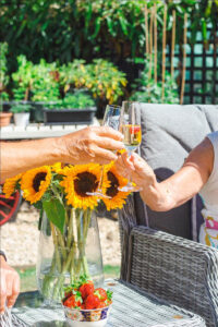 Guests toasting outdoors champagne and strawberries
