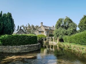 Photo of a country manor seen from a river in the Cotswolds