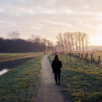 photo of a hiker on a countryside path next to a river to illustrate self-guided walking vacations in Dorset